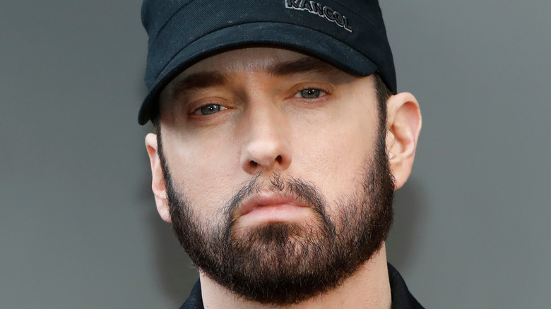 Eminem posing, wearing baseball cap