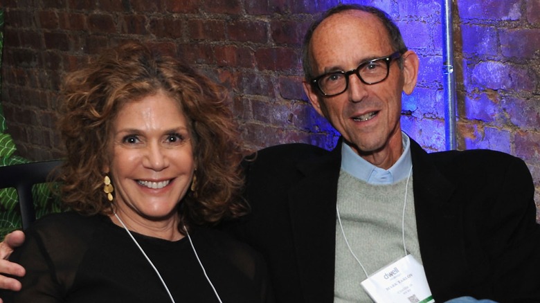 Judy and Mark Tarlov posing in front of a brick wall