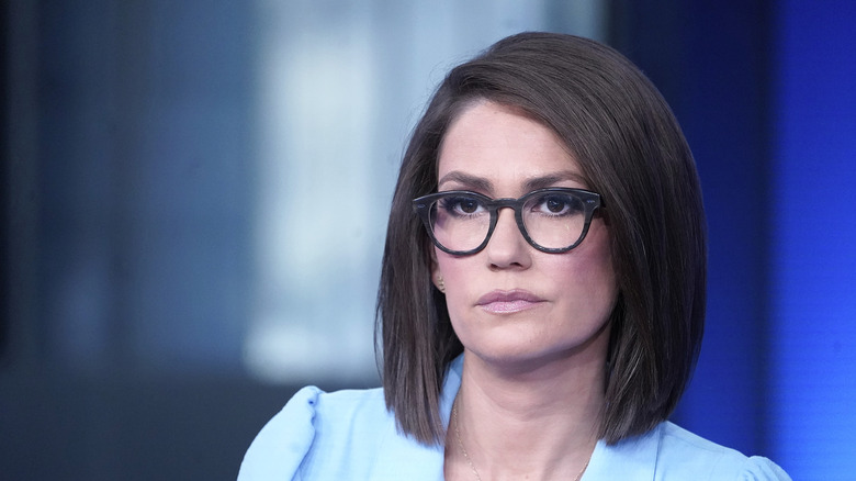 Jessica Tarlov wearing glasses in a TV studio with a serious expression