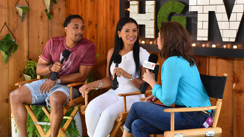 DeRon Jenkins and Page Turner smiling on stage holding mics and being interviewed by woman at HGTV event