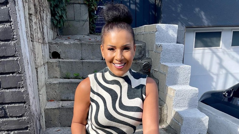 Page Turner smiling as she sits on concrete steps outside
