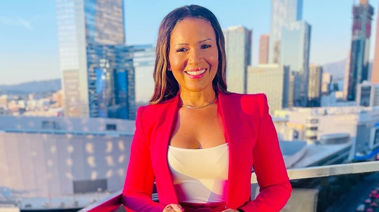 Page Turner smiling on balcony with skyscrapers in the background