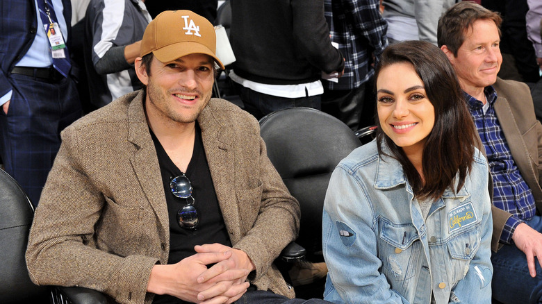 Ashton Kutcher and Mila Kunis at a game