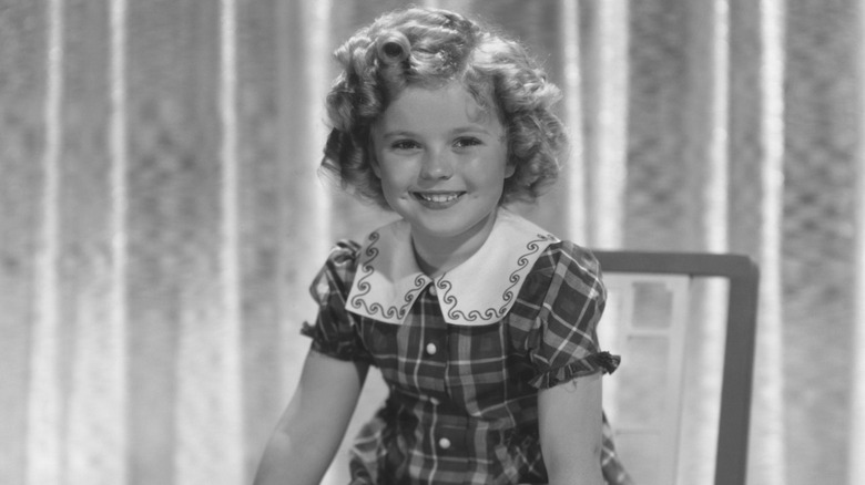Shirley Temple sitting in a chair and smiling