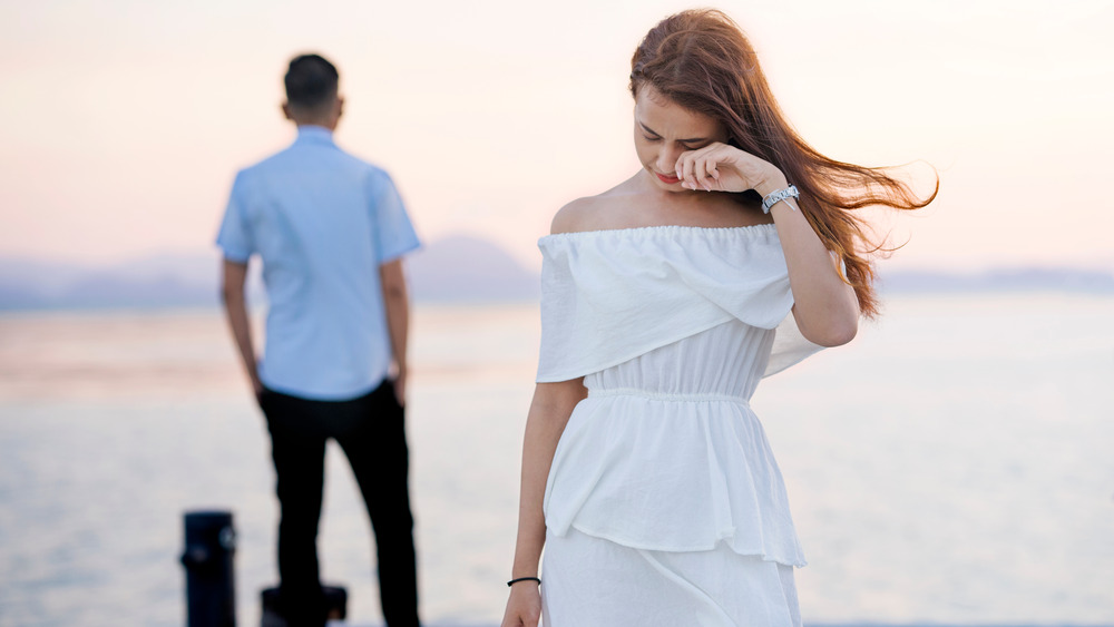 Couple breaking up on pier