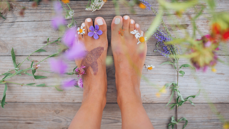 Tattooed feet surrounded by flowers