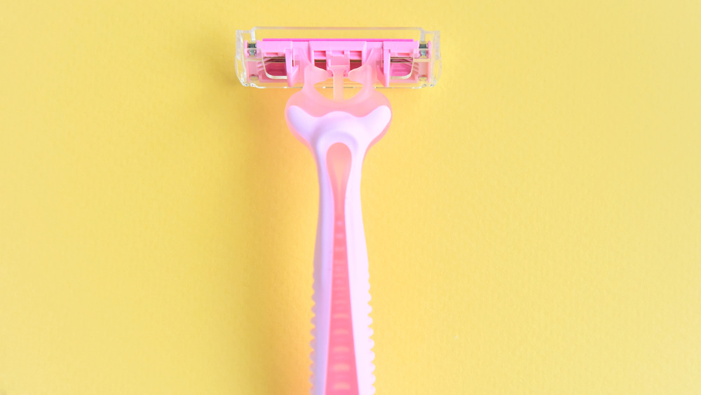 Pink razor against yellow background