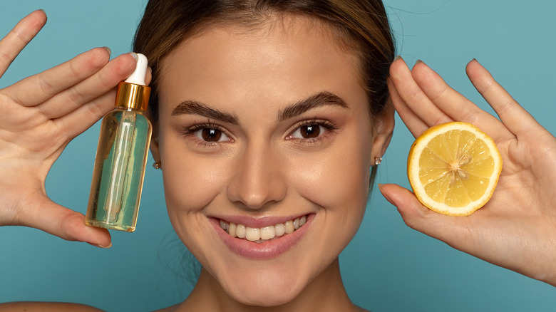 Woman holding lemon and serum