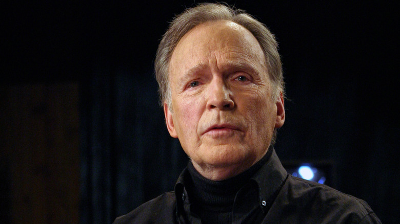 Dick Cavett photographed in front of a black background