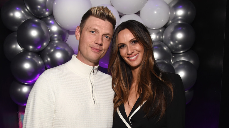 Nick Carter and Angel Carter Conrad posing in front of balloons