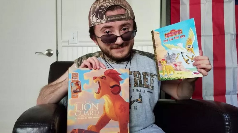 Atticus Shaffer holding books for "The Lion King" and "The Lion Guard."