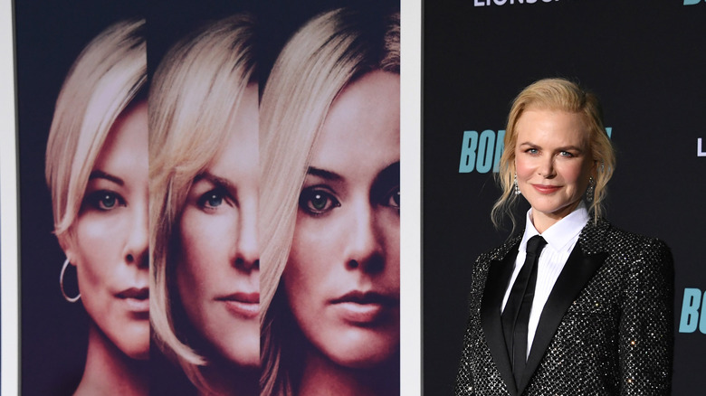 Nicole Kidman standing in front of a poster for Bombshell