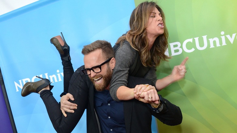 Bob Harper carrying Jillian Michaels across his back at an NBCUniversal event
