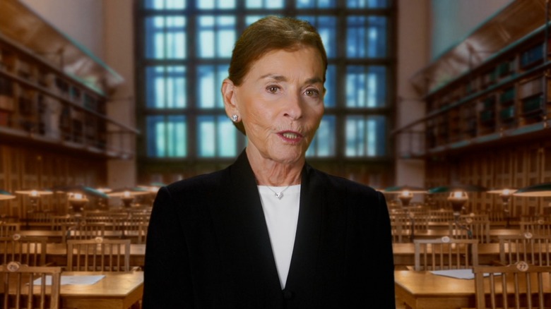 Judge Judy standing in front of a green-screened library on "Justice On Trial"