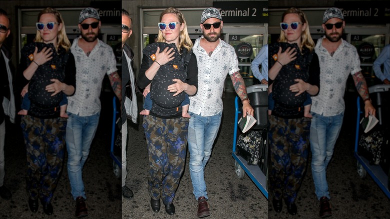 Julia Stiles, Preston Cook, and one of their children at an airport