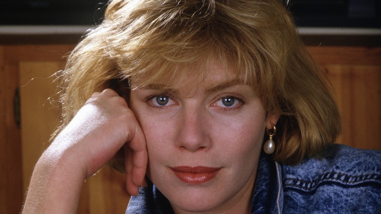 A close up image of young Kelly McGillis smiling and posing with blonde hair.