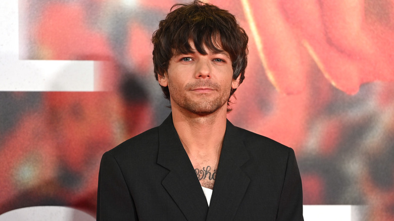 Louis Tomlinson posing for photos