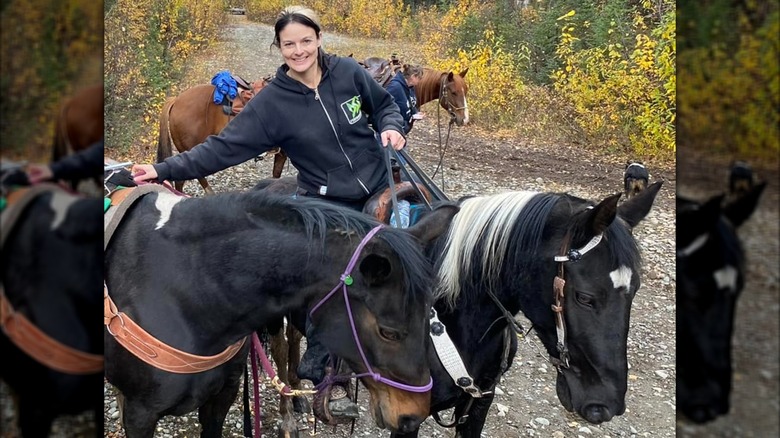 Lisa Kelly riding a horse while surrounded by horses in 2022.