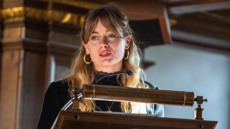 Cressida Bonas speaking into microphones on podium