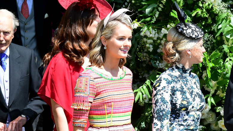 Cressida Bonas smiling and walking outside with wedding guests at Prince Harry and Meghan Markle's wedding