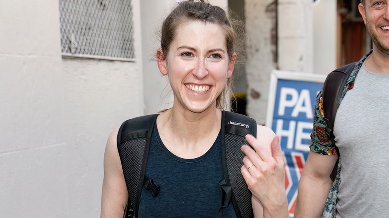 Eden Sher smiling as she is being photographed in street by paparazzi