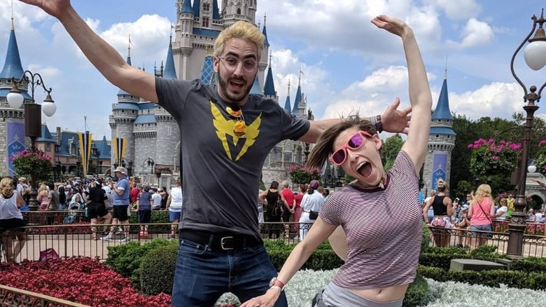 Eden Sher and Nick Cron-DeVico jumping in front of Disneyland Castle