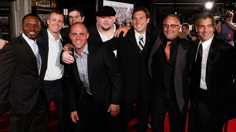 Tommy Hinkley  smiling in a cast photo for the movie Leatherheads on the red carpet in a dark suit.