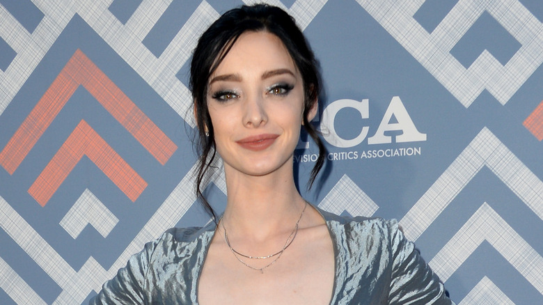 Emma Dumont wearing a blue dress