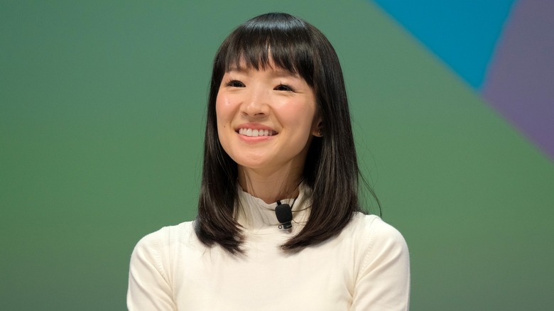 Marie Kondo smiling against a green, purple, and blue background