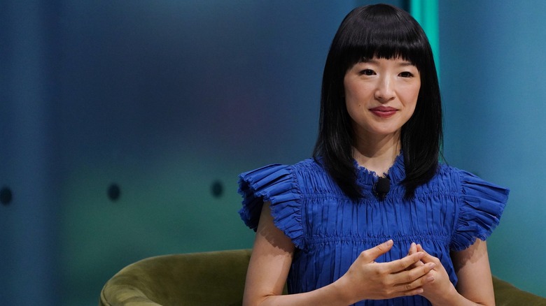 Marie Kondo speaking onstage while sitting in a chair