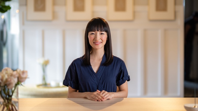 Marie Kondo sitting at a table looking business-like in an image from Sparking Joy on Netflix