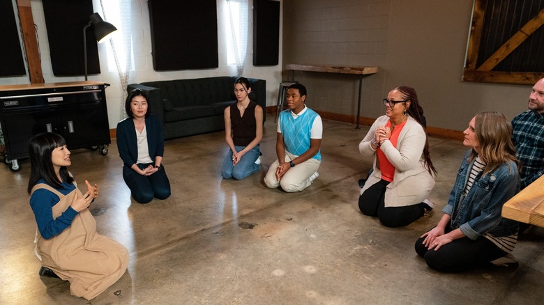 Marie Kondo and a group of devotees kneeling on the floor in a circle together, from Sparking Joy on Netflix