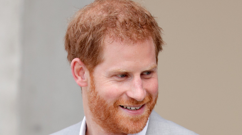 Prince Harry smiles will looking to the side.