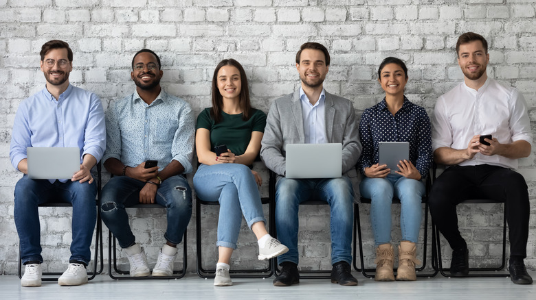 diverse group of job candidates with phones and laptops