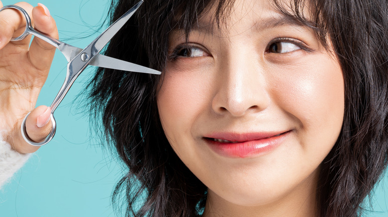 woman smiling with scissors