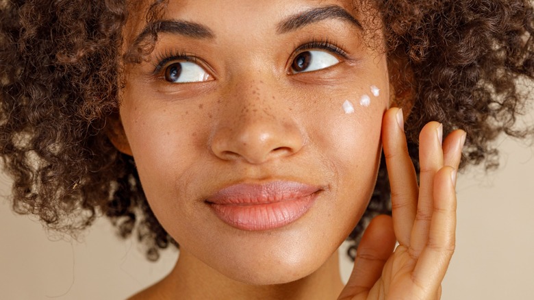 Woman applying skin cream