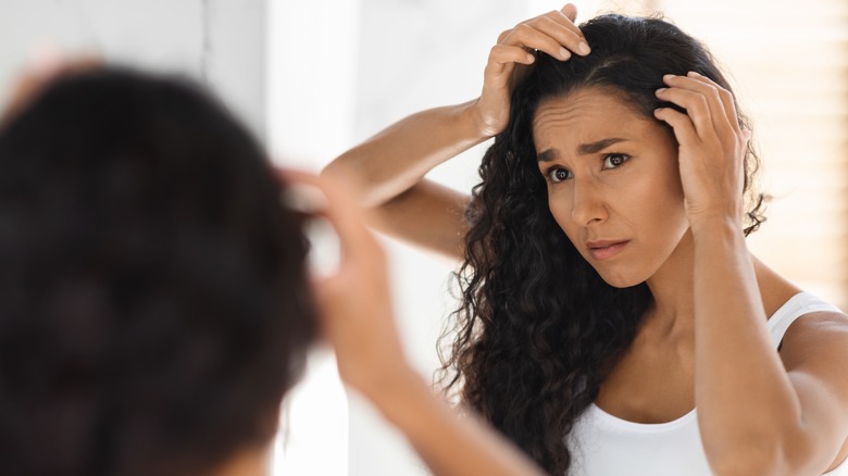 Woman looking at dandruff mirror