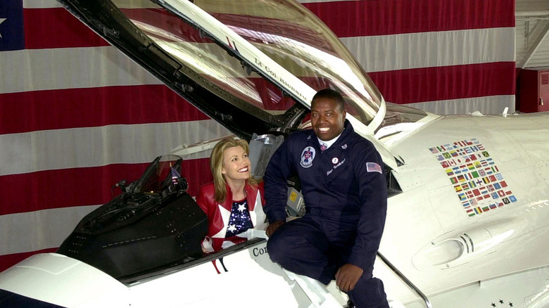 Vanna White sits in a one person US airplane looking up at the pilot