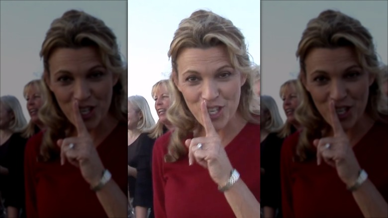 Vanna White looking into the camera and shushing while showing off diamond ring