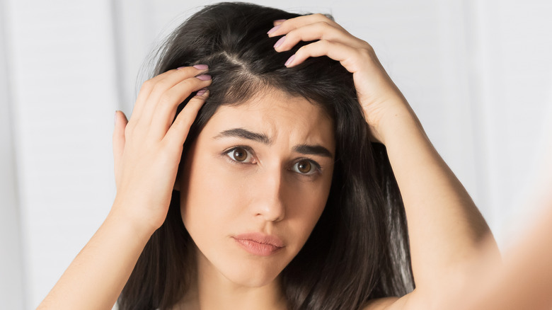 Woman looking at her hair in mirror