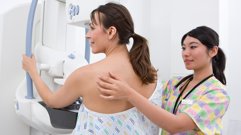 Technician performing mammogram