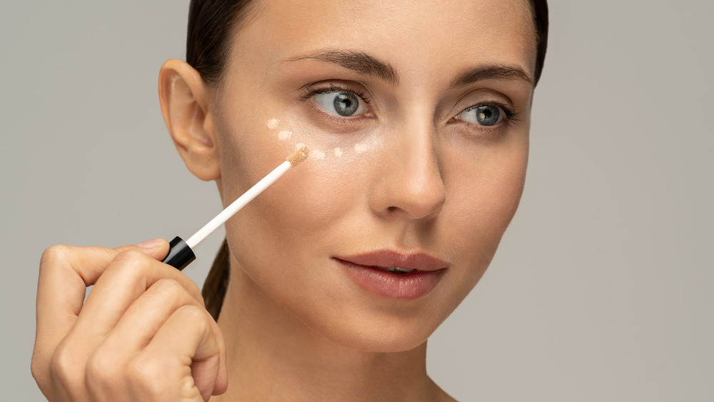 Woman putting on makeup.