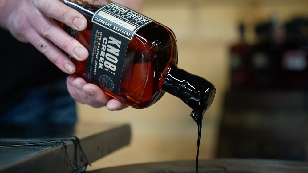 Bourbon bottle being sealed with wax