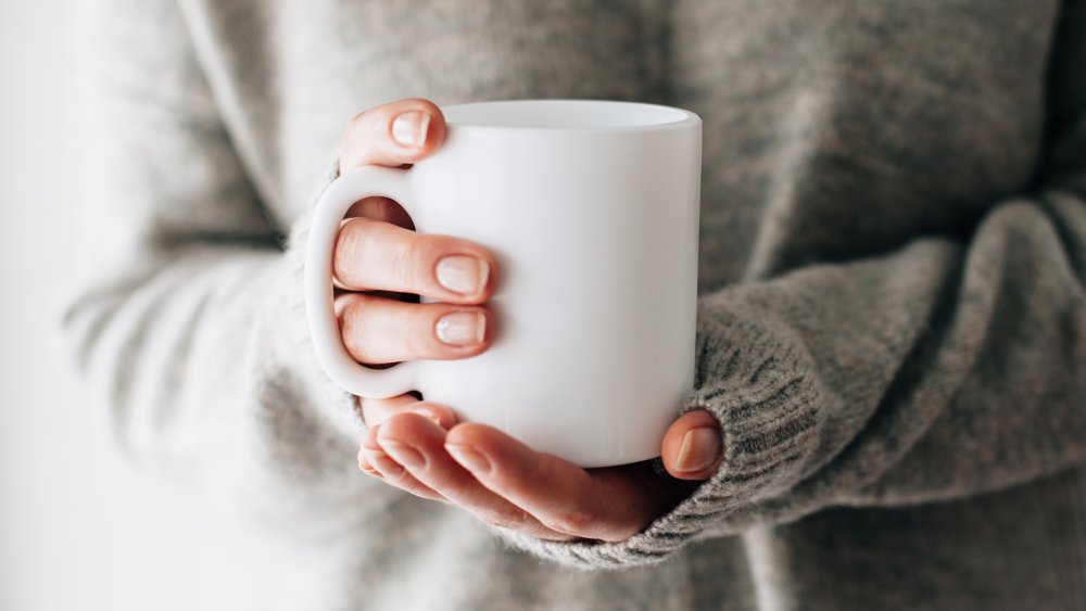 woman holding a mug of hot water