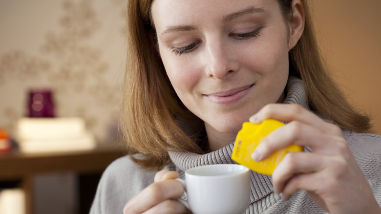 Woman adding artificial sweeteners