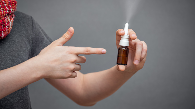 Man pointing to nasal spray bottle