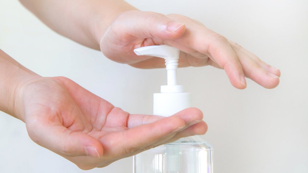 A woman's hands using clear hand sanitizer