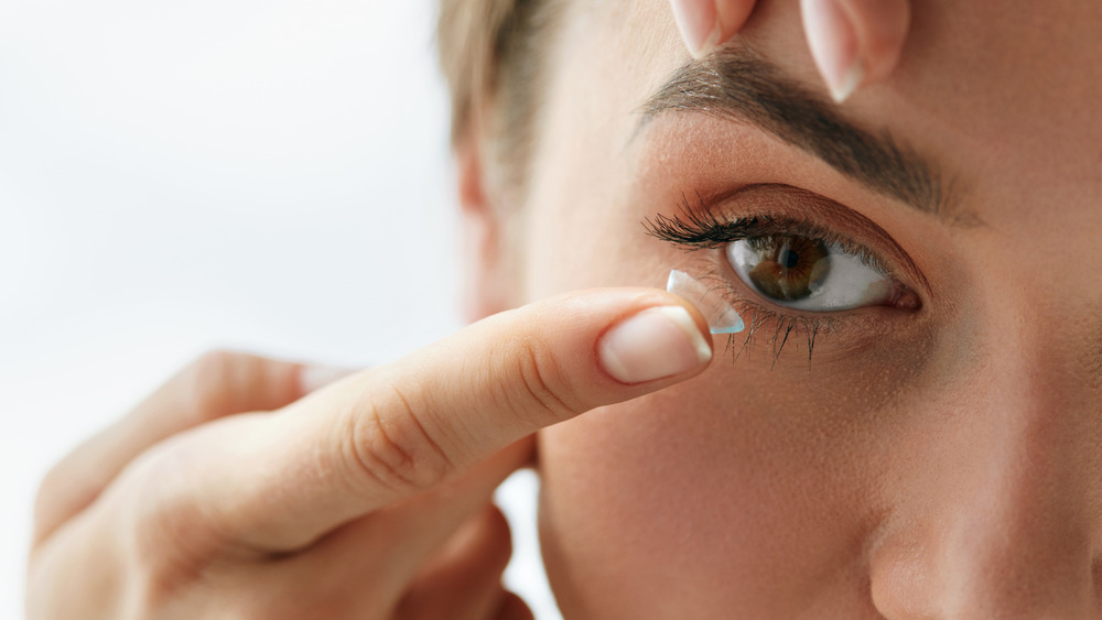 Woman applying contact lenses