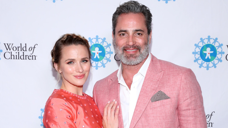 Shantel VanSanten places a hand on Victor Webster's chest.