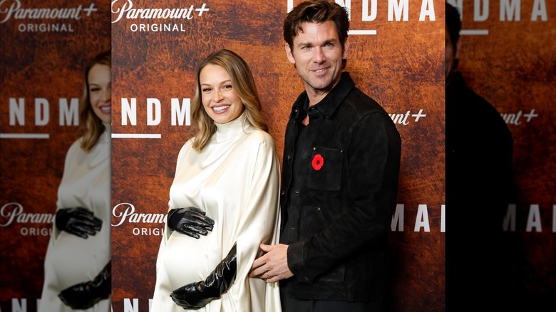 Pregnant Kayla Wallace cradles her baby bump next to Kevin McGarry.